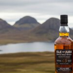Isle of Jura whisky flessen met de Paps of Jura op de achtergrond